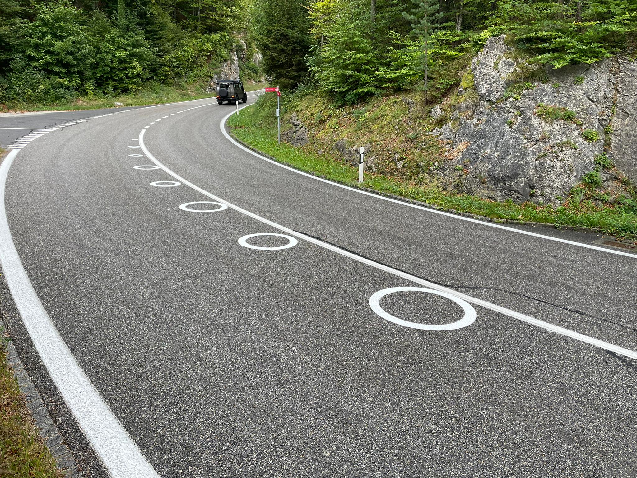 Kreise auf der Fahrbahn halten Motorradfahrer auf der Ideallinie